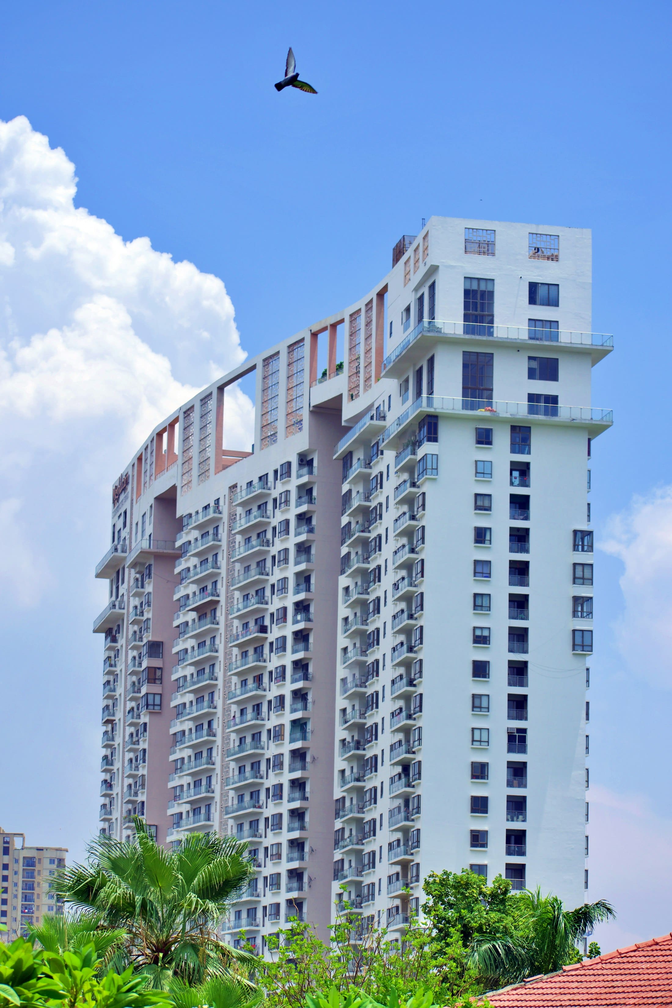 A high-rise residential tower against a blue sky in Noida