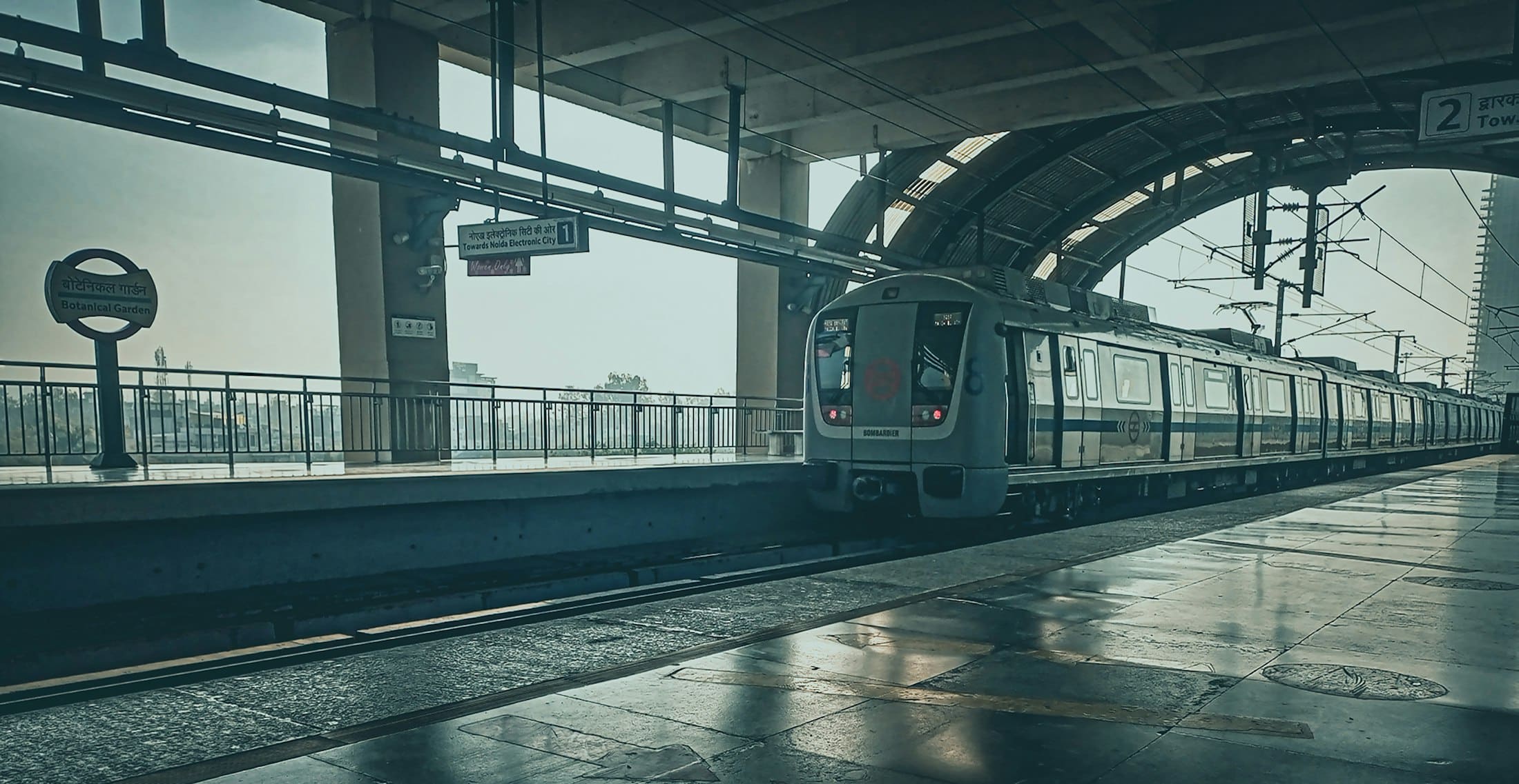 A metro train waiting at an empty platform in Noida