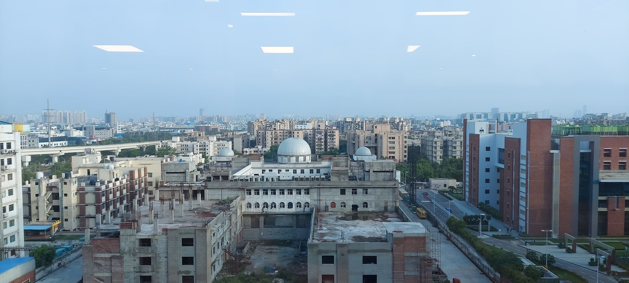 A rooftop view across low-rise buildings in Noida